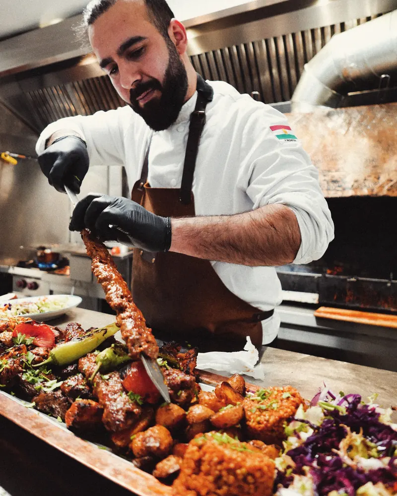 Le chef dresse une planche de grillades au charbon — restaurant kurdo-arménien à Dunkerque