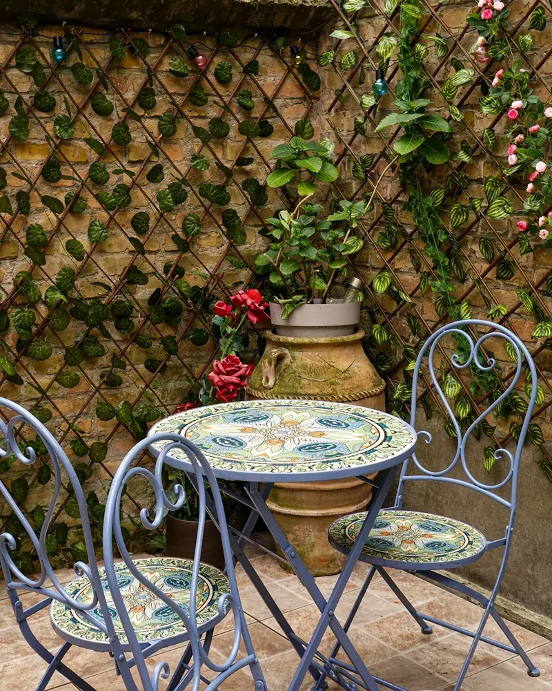 Terrasse de la cour, treillis fleuri et chaises en fer forgé à Malo-les-Bains
